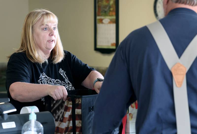 Susan Kauffman, of Kauffman Turkey Farms, helps a customer Monday, Nov. 6 2023, at their farm in Waterman. The Kauffman’s are retiring soon and are currently selling what they have left in stock before closing.