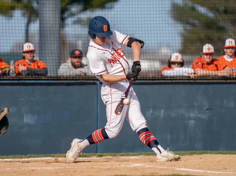 Oswego’s Troy Vosburgh (18) singles driving in a run against Plainfield South during a baseball game at Oswego High School on Monday, April 11, 2022.