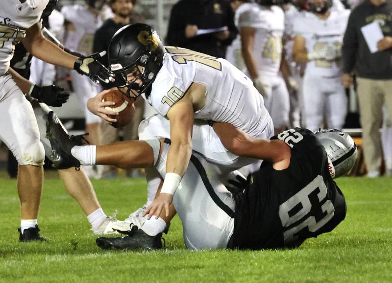Sycamore's Burke Gautcher is sacked by Kaneland's Jake Buckley during their game Friday, Oct.4, 2024, at Kaneland High School in Maple Park.