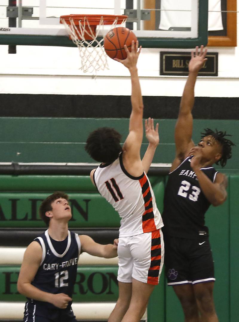 McHenry's Hayden Stone shoots the ball between Cary-Grove’s Jake Hornok and Hampshire’s Adrien Ugochukwu during the boy’s game of McHenry County Area All-Star Basketball Extravaganza on Sunday, April 14, 2024, at Alden-Hebron’s Tigard Gymnasium in Hebron.