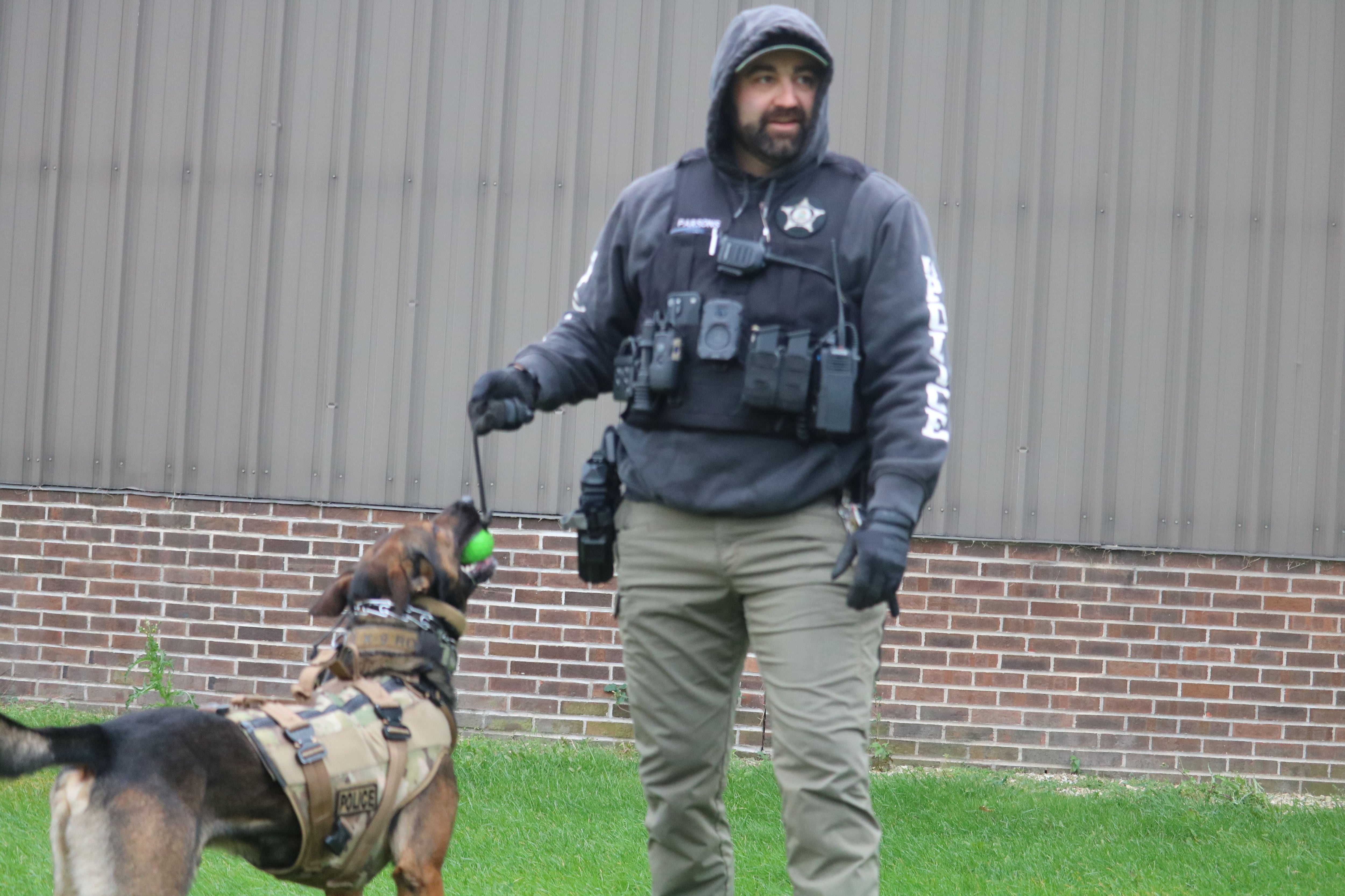 DeKalb police Sgt. Steve Parsons (right) is seen playing with Chase Oct. 22, 2025, outside the former GE plant in DeKalb.
