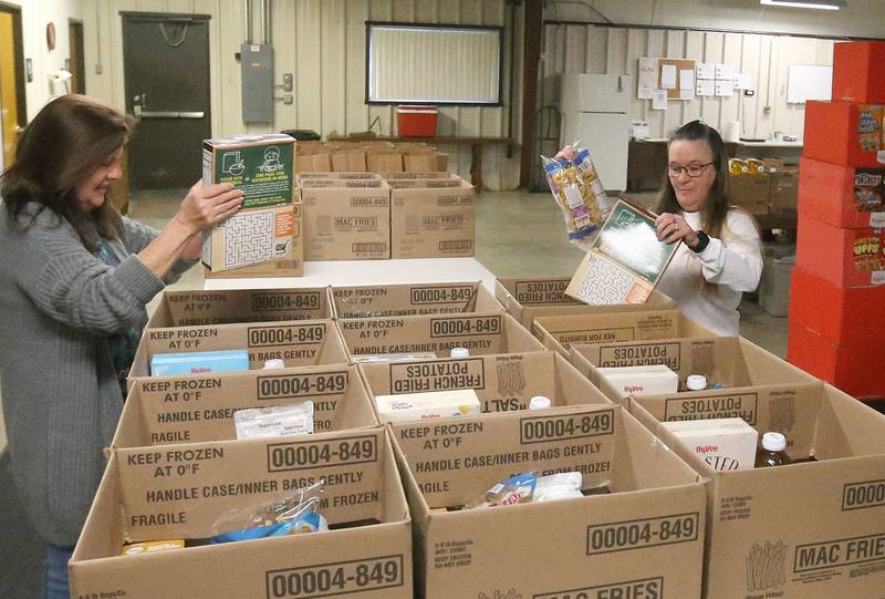 Mary Jo Credi Executive Director at the Illinois Valley Food Pantry, fills boxes of food with Trinity Roark on Tuesday, Oct. 28, 2025 at the Illinois Valley Food Pantry in Peru. Food shortage will worsen local food pantries due to the the shutdown.