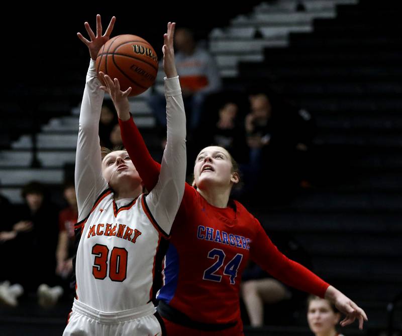 McHenry's Ali Ahrens battles for a rebound against \Dundee-Crown’s Mikayla Saas during a Fox Valley Conference girls basketball game on Tuesday, Dec. 12, 2023, at McHenry High School.