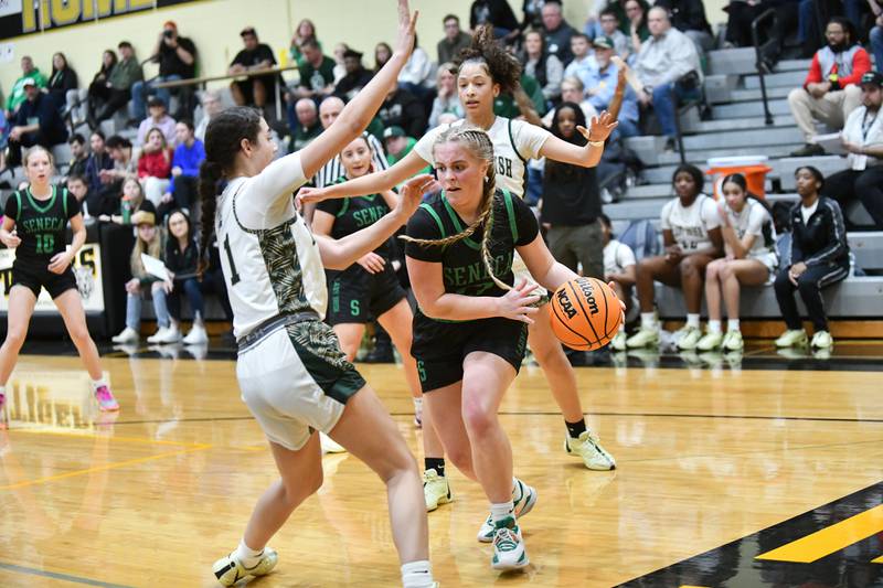 Seneca's Emma Mino looks to pass around Bishop McNamara's Trinity Davis during the Lady Irish's 51-30 loss to Bishop McNamara in the IHSA Class 2A Herscher sectional semifinal on Tuesday, Feb. 25.