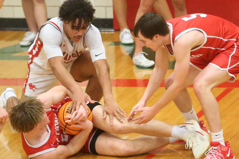 Ottawa's Owen Sanders falls on a loose ball as L-P's Marion Persich tries to force a jump as Ottawa's Klyer Araujo helps out on Friday, Feb. 7, 2025 in Sellett Gymnasium at L-P High School.