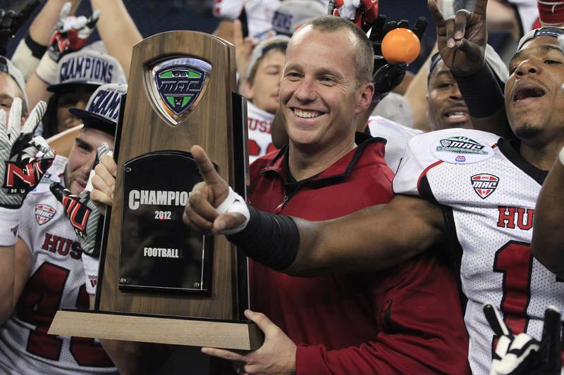 Former Northern Illinois coach Dave Doeren holds the Mid-American Conference championship trophy after his team defeated Kent State 44-37 in double overtime, Friday, Nov. 30, 2012 in Detroit.