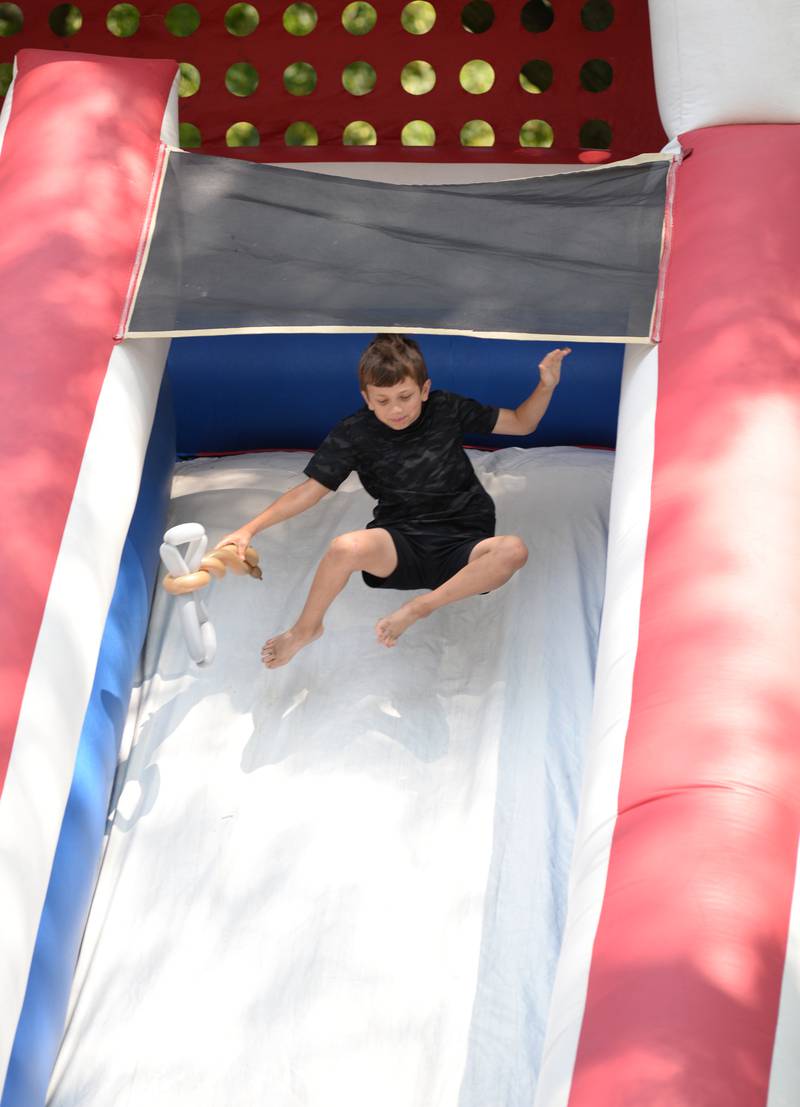 Thaddeus Gouzoulis of Hinsdale enjoys going down the slide during the Hinsdale 4th of July Family Festival Tuesday June 4, 2023.
