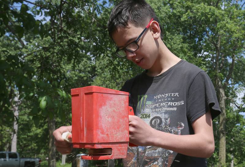 Milton Pope student Truman McGeorge spreads pollinator seed on Friday, May 23, 2025 near entrance to Illini State Park in Marseilles. Milton Pope students volunteered their time planting seed, pulling up rocks, spreading mulch and helping with other tasks.