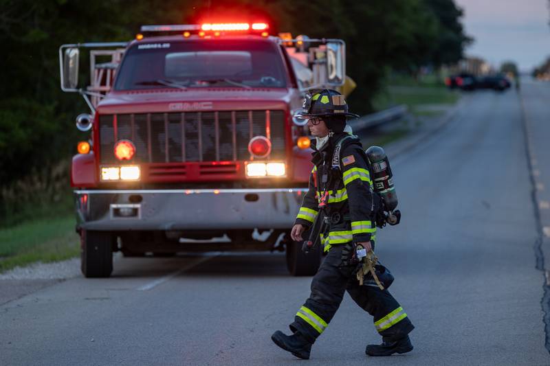 Firefighter walks across street in front of Firetruck on Saturday, July 19, 2025, the 1400 Block of U.S. Route 6 in Ottawa.