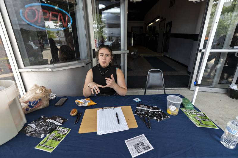 Kory McGowan sits outside of The Spark on Friday, Aug. 1, 2025, welcoming in guests to tour the performance arts center. The group behind the renovation held the opening to coincide with Sterling’s popular Hot Dog Day.