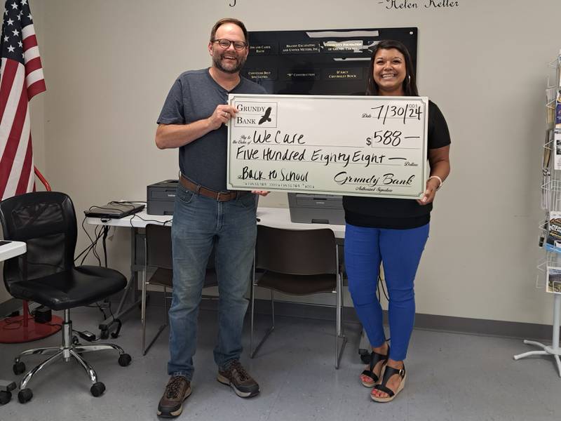 Eric Fisher (left) of We Care of Grundy County accepts a check from Christina Mendez of Grundy Bank.