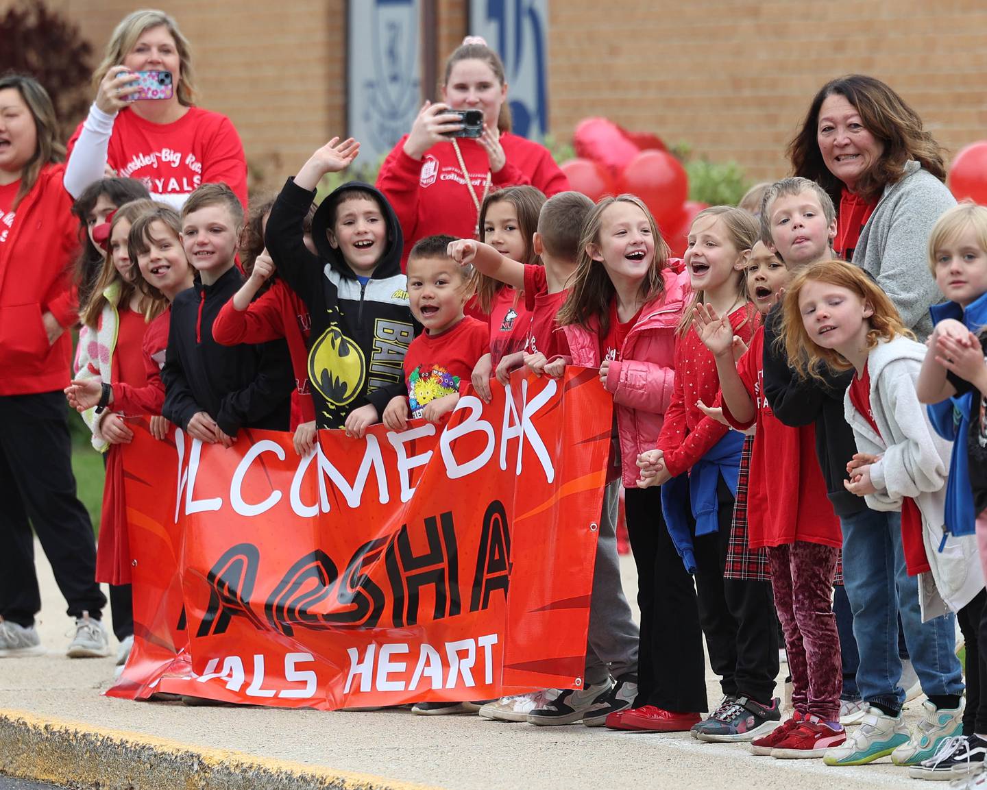 First grade Hinckley-Big Rock Elementary School classmates of Marshall Morong, 7, cheer Monday, May 5, 2025, as he arrives for his first day back following months waiting for, and eventually receiving, heart transplant surgery at Lurie Children’s Hospital of Chicago. Morong arrived in style in a Tesla Cybertruck donated for use by Telsa of Naperville, along with an escort by Hinckley and Big Rock first responders.