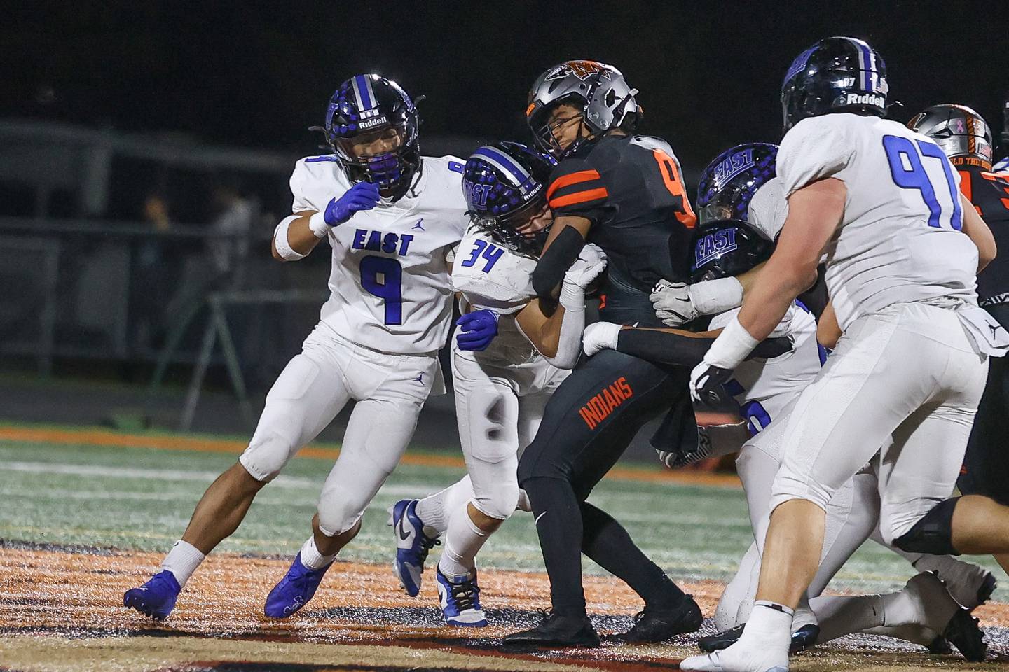 Lincoln-Way East’s Miko Moraga (9) and Charlie Palmer (34) wrap up Minooka’s Paris Spears for no gain on Friday, Nov. 8, 2024 in Minooka.