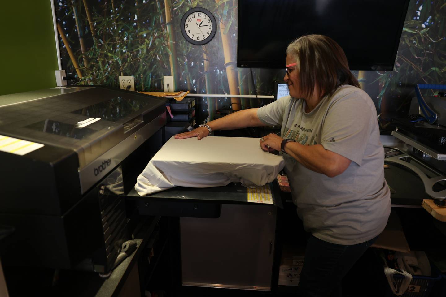 Shorewood’s Big Frog Custom T-Shirts & More store manager Camille Watts prepares a t-shirt for printing on Thursday, Jan. 18th, 2024.