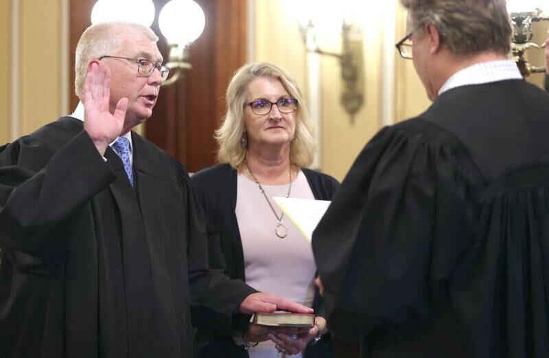 Judge Philip Montgomery is sworn in as a circuit court judge for the 23rd Judicial Circuit Court by Judge Bradley Waller as his wife Lisa Montgomery holds the bible Friday, July 15, 2022, at the DeKalb County Courthouse in Sycamore.