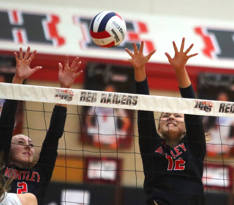 Huntley’s Rachael Hein, left, and Summer Massow, right, block against Hampshire in girls varsity volleyball at Huntley High School on Thursday, October 23, 2025.
