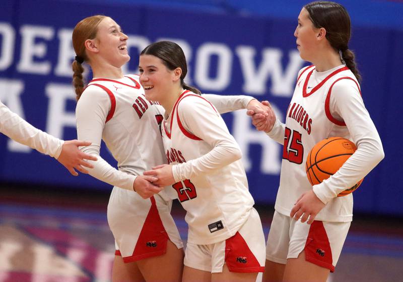 From left, Huntley’s Avery Suess, Aubrina Adamik and Evelyn Freundt celebrate a Red Raider win over Mundelein in varsity girls basketball Komaromy Classic tournament  action on Tuesday, Dec. 30, 2025, at Dundee-Crown High School in Carpentersville.