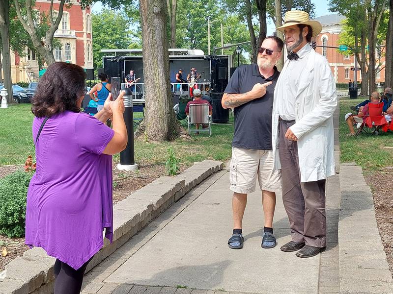 Jimmy Wilson of Oak Hill, Ohio, poses with a Lincoln impersonator Saturday, July 27, 2024, during the inaugural Drinkin' with Lincoln at Washington Square in Ottawa.