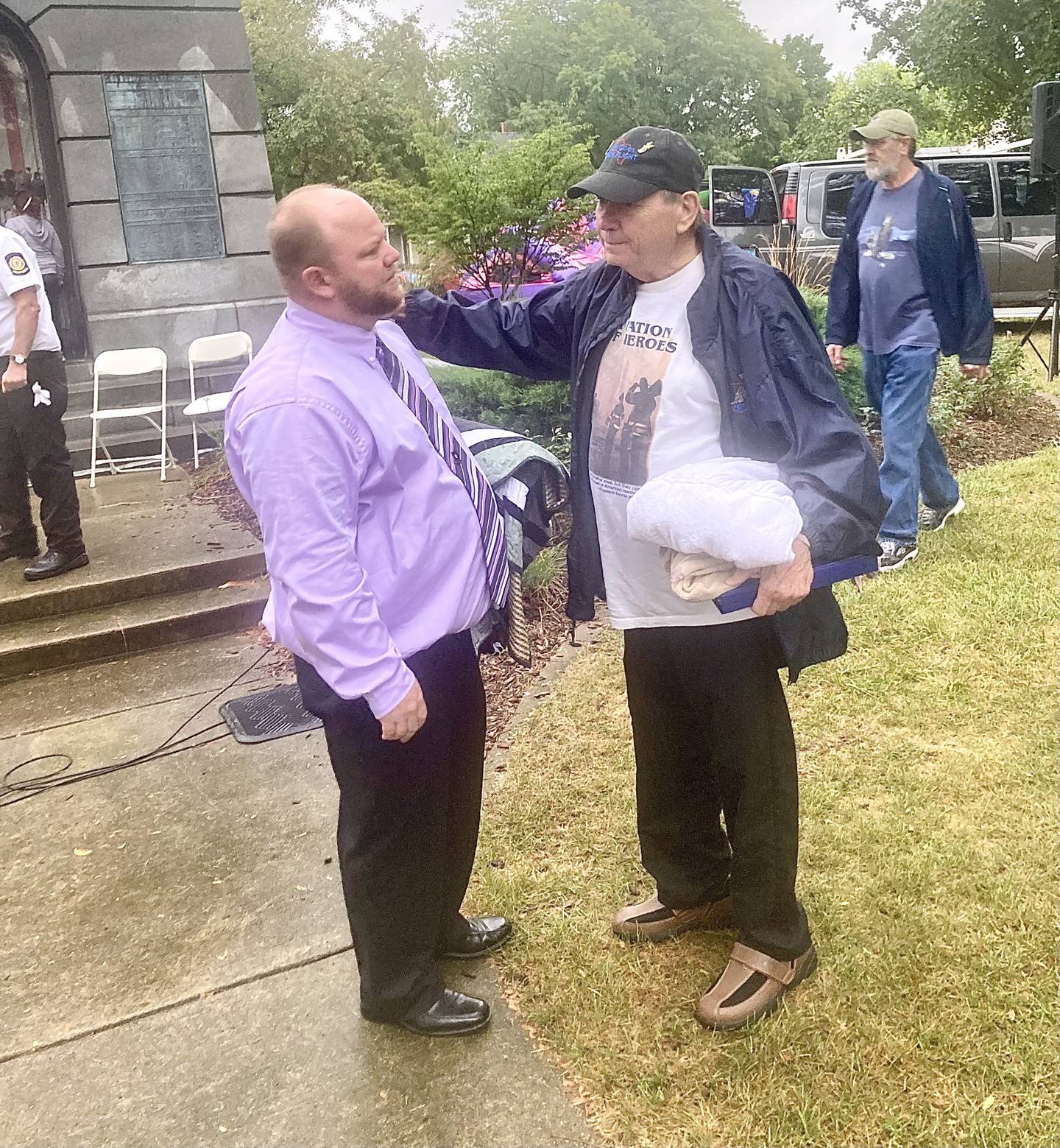 Mitch McCoy (left) of Princeton, retired US Army veteran, visits with Dan Hollinsaid of Princeton, after Monday's 9-11 Remembrance Ceremony, at Soldiers and Sailors Park in Princeton. Hollinsaid lost his son, "Linc," during the war on terrorism. He spoke during the ceremony.
