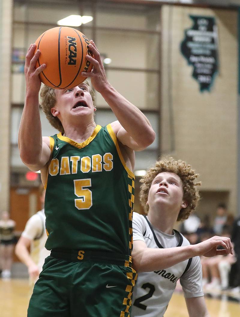 Crystal Lake South's Carson Trivellini drives to the basket in front of Sycamore's Logan Hodges during an IHSA Class 3A Woodstock North Sectional semifinal.basketball game on Wednesday, March 4, 2025, at Woodstock North High School.