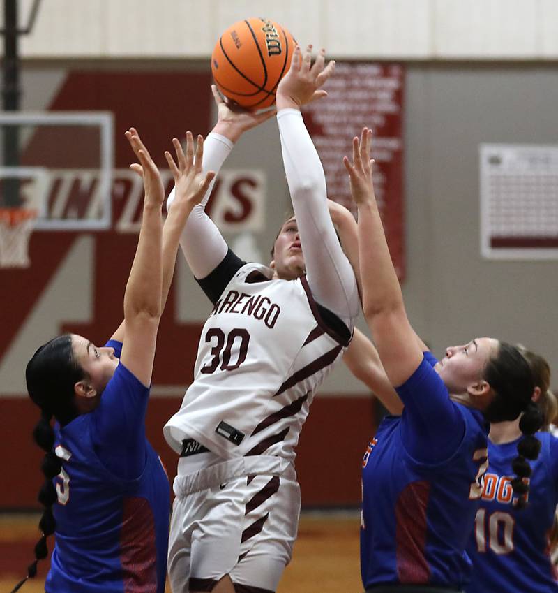 Marengo's Macy Noe (center) shoots the ball between Genoa-Kingston's Zoe Boylen (left) and Regan Creadon (right) during an IHSA Class 2A Marengo Regional semifinal girls basketball game on Monday, Feb. 16, 2026, at Marengo High School.