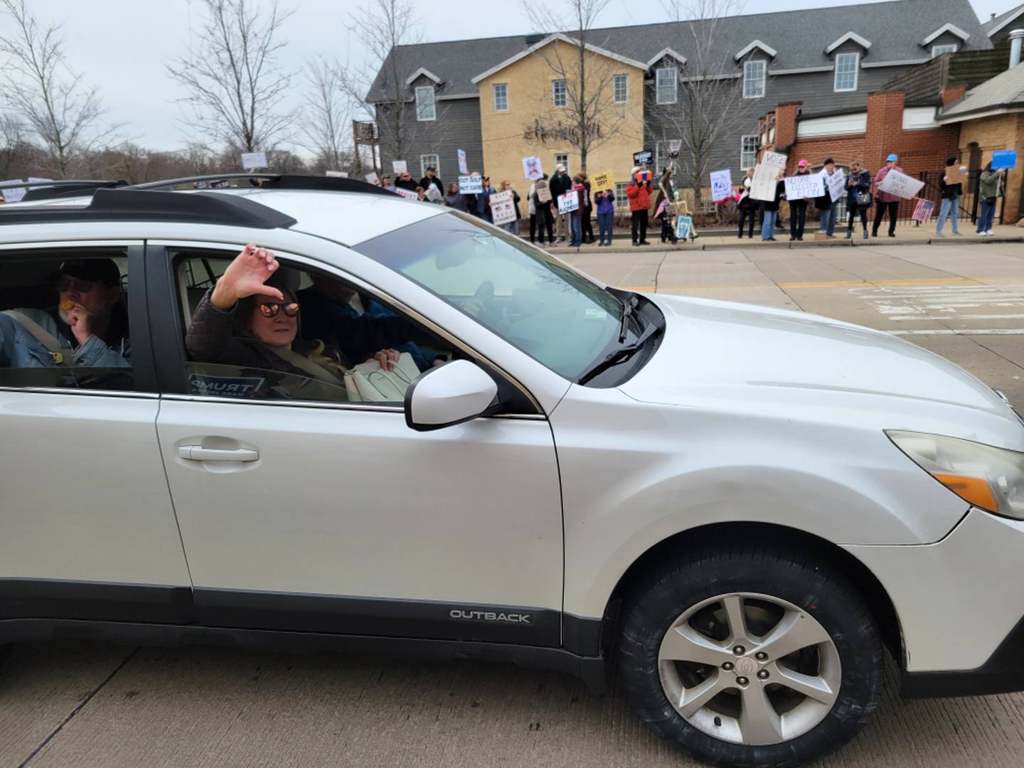 A motorists gives a thumb's down to counter protesters at the Hands Off! rally April 5 in Geneva. Some 6,000 people filled both sides of the Illinois Route 38 bridge over the Fox River. About two dozen Trump supporters counter protested.