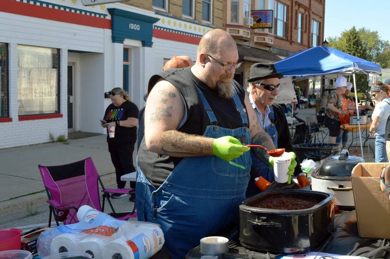 Mark Bellini (left) scoops a cup of sweet chili for a Polo Chili Cook-Off and Block Party attendee on Saturday, Sept. 28, 2024, in downtown Polo. Bellini, Kirby Witmer (right) and Kevin Rundall won the People's Choice award with their sweet chili.