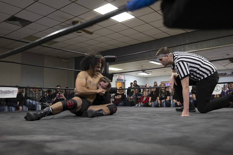 Zay-K47 (Isaiah Harris) gets Lt Dan (Dan Gusler) in a headlock Saturday, Feb. 4, 2023 during their match. Typically wrestlers are grouped in two separate categories, heels, those who are cheats or unlikeable, and the heroes. These characters often switch sides for an added conflict arc.