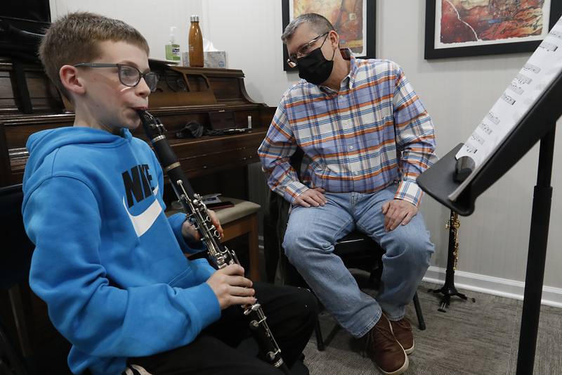 Music teacher Keith Hulen watches as Ethan White, 12, of Crystal Lake, plays the clarinet during a lesson Tuesday, Feb. 22, 2022, at Encore Music Academy, 87 N. Williams St., in Crystal Lake. The academy moved into its new location over Thanksgiving week last year. The larger location allows for the expansion of its private student instruction and also has a large space suitable for performing.