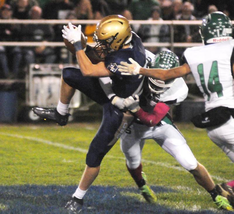 Marquette's Pete McGrath catches a pass as he is hit by Seneca's Asher Hamby and Kevin Einhaus (14) at Gould Stadium on Friday, Oct. 6, 2023.