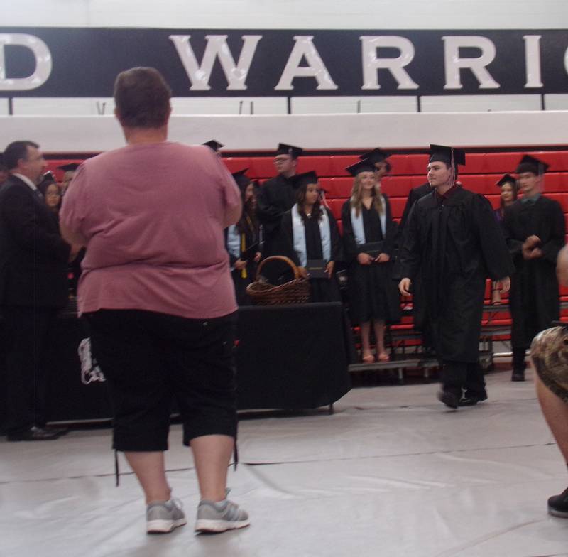 Woodland graduates receive their diplomas Sunday, May 19, 2024, and get their photos taken during the ceremony in the school's gymnasium.