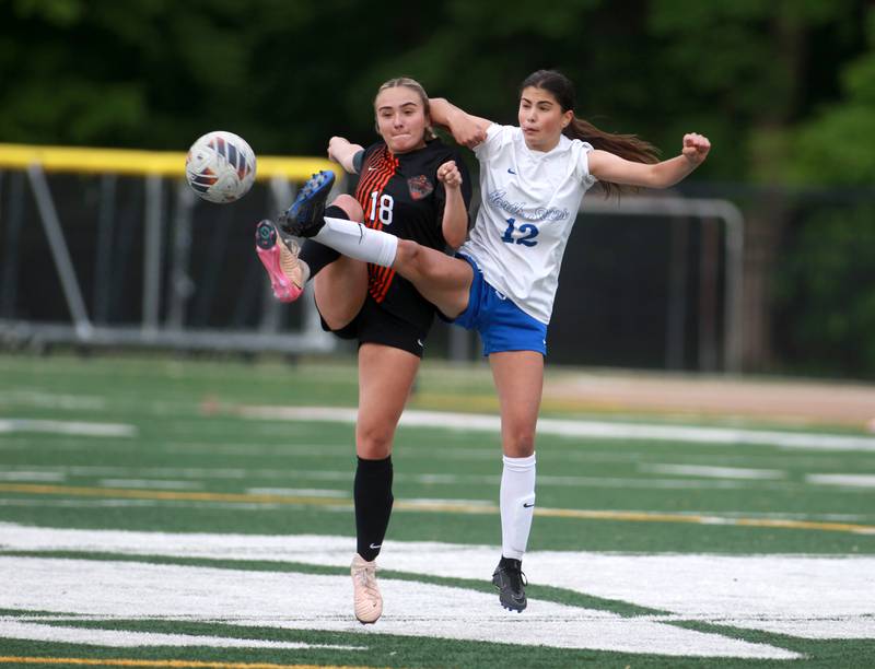 St. Charles East's Payton Rivard and St. Charles North's Madisen Shanahan kick the ball during a Class 3A Glenbard West Sectional semifinal game on Tuesday, May 27, 2025 in Glen Ellyn.