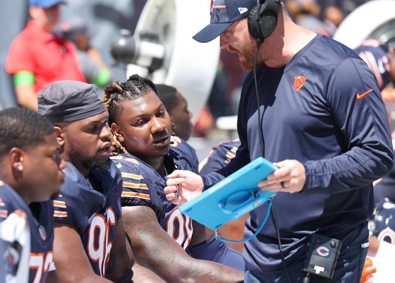 Chicago Bears defensive tackle Zacch Pickens (left) and defensive tackle Gervon Dexter Sr. listen to a coach during their preseason game against the Tennessee Titans Saturday, Aug. 12, 2023, at Soldier Field in Chicago.