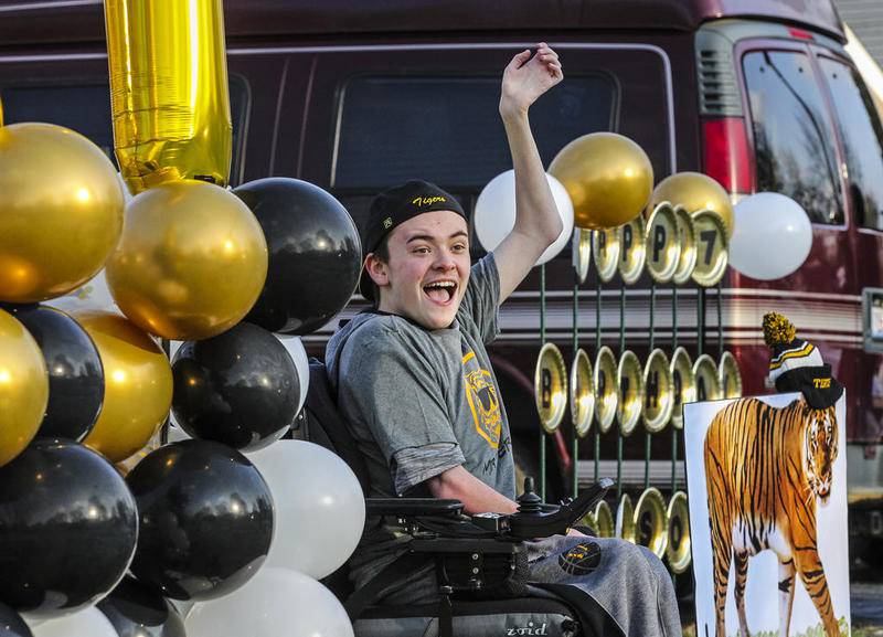Lawson Sizemore waves to a vehicle full of friends and classmates on April 17, 2020, during a surprise birthday parade for his 17th birthday in Shorewood.