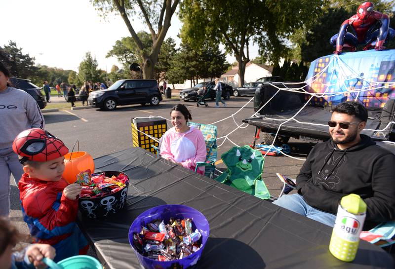 Nicholas Marco of Brookfield gets candy from Elizabeth Maaca and Kelvin Tapia of Countryside on Saturday, Oct. 12, 2024 during a Trunk or Treat event at Sedgwick Park in La Grange.