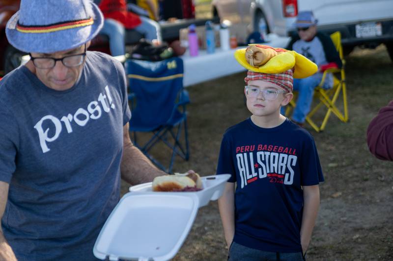 Children watch a man prepare a sausage Saturday, Oct. 19, 2024, at the annual Harvest Fest on at Kirby Park in Spring Valley.