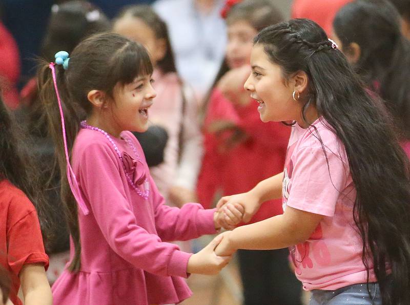 DePue Students Xenia Ortega and Illiana Morales-Alfaro dance to music by the NIU Steelband on Friday, Feb. 14, 2025 at DePue School.