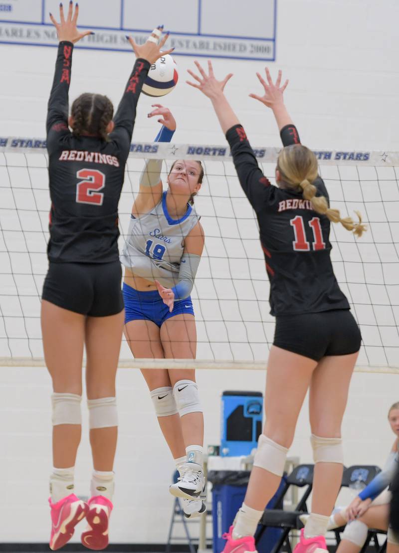 St. Charles North's Alex Bardouniotis (19) hits the ball past Benet's Gabby Stasys (2) and Ellie Stiernagle (11) during a game on Wednesday, September 20, 2023.