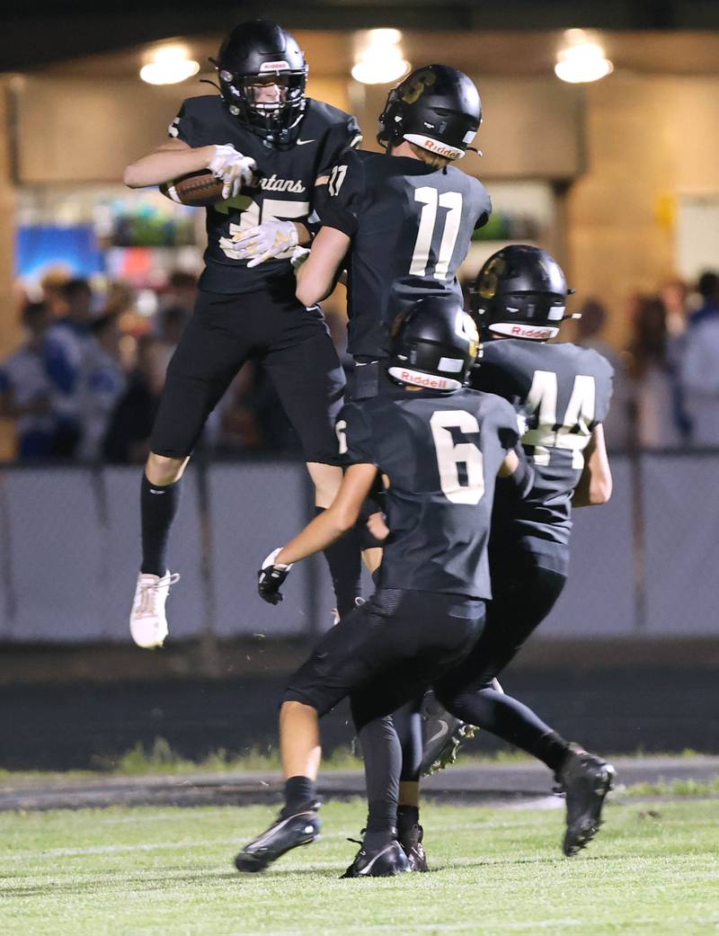 Sycamore's Aidan Wyzard (left) celebrates with teammates after scoring a touchdown on a punt return during their game against Woodstock Friday, Sept. 8, 2023, at Sycamore High School.