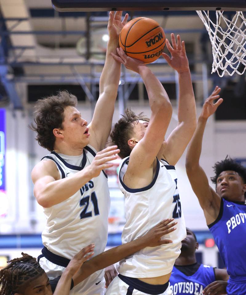 Downers Grove South's Daniel Laurich (left) and Daniel Sveiteris go after a rebound among three Proviso East defenders during their game Friday, Feb. 14, 2025, at Downers Grove South High School.