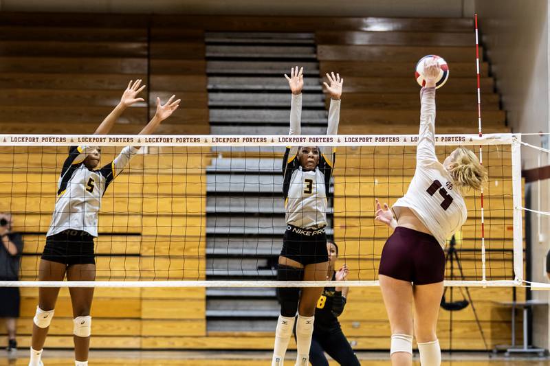 Lockport's Hutsyn Timosciek goes for the kill as Joliet West's Mady Gant and Na’Riah Autman attempt to block during a varsity volleyball game at Lockport Township High School on Sept. 17, 2025.