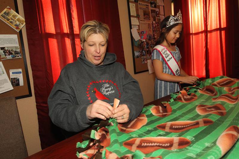 Candace H. Johnson for Shaw Local News Network
April Soulak-Andrews, president and founder, and Audrey Ruhl, 10, (Ms. Illinois PreTeen 2023), both of Antioch work together to make a no-sew fleece blanket with a football theme on it during The Penny’s Purpose Annual Blanket Drive in Antioch. Audrey is also the Youth Ambassador for The Penny's Purpose.