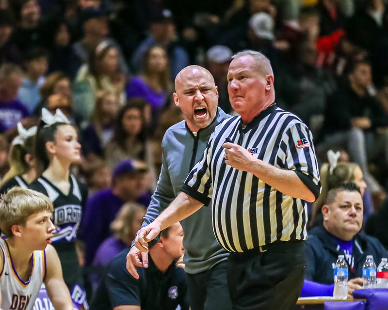 Downers Grove North's head coach Jim Thomas has a disagreement with the referee during basketball game between Downers Grove South at Downers Grove North. Dec 16, 2023.