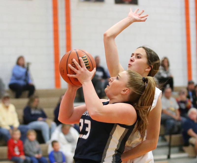 Fieldcrest's Riley Burton runs into the lane to score on a layup as Marquette's Kaitlyn Davis defends during the Integrated Seed Lady falcon Basketball Classic tournament on Monday, Nov. 13, 2023 at Flanagan High School.