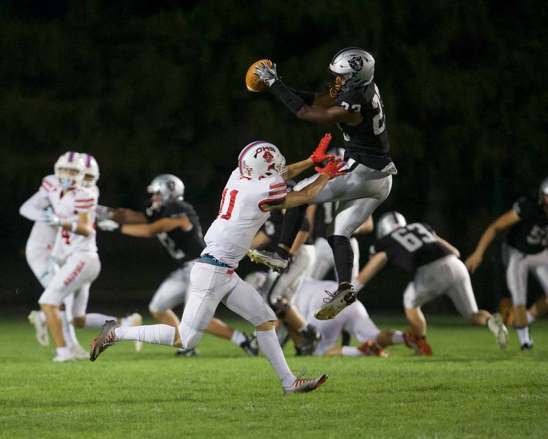 Kaneland's Aric Johnson makes the catch as Ottawa's Weston Averkamp tries to intercept the ball on Friday, Sept. 22, 2023 in Maple Park.