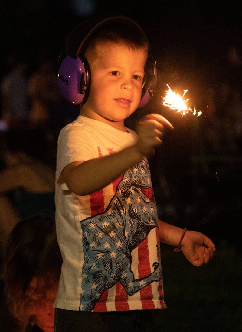 Rhett Kennedy, 5, waves a sparkler around during North Aurora's annual Independence Day celebration at Riverfront Park in North Aurora on Monday, July 3, 2023.
