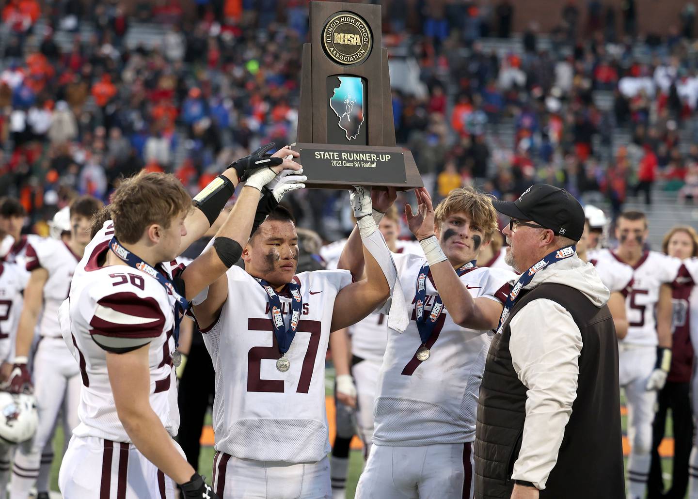 Prairie Ridge captains accept the second place trophy after their IHSA Class 6A state championship loss to East St. Louis Saturday, Nov. 26, 2022, in Memorial Stadium at the University of Illinois in Champaign.