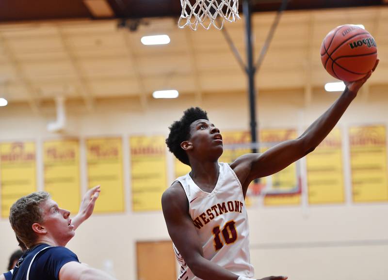 Westmont's Malachi Boatright (10) does a reverse layup in front of IC Catholic's Andrew Hill during a game on Jan. 5, 2024 at Westmont High School in Westmont.