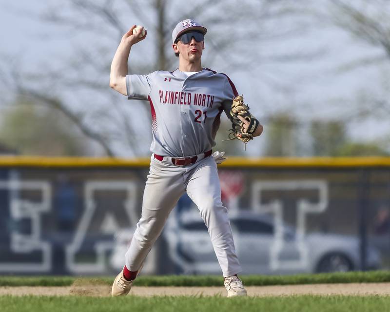 Plainfield North's Chase Holtzman (21) throws to first after fielding a grounder to third during baseball game between Plainfield North at Oswego East, Monday, April 28, 2025 in Oswego.