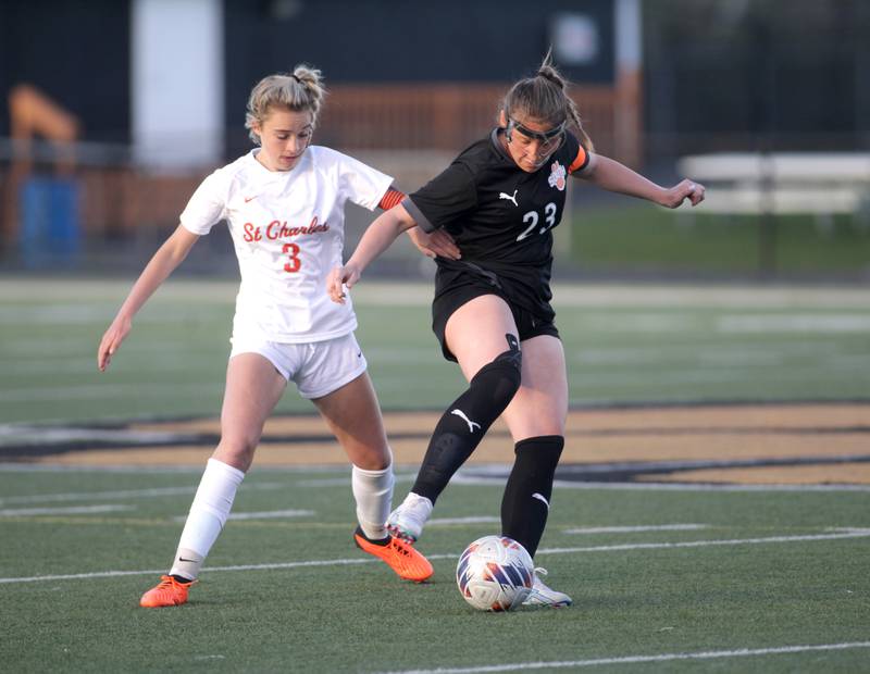 St. Charles East’s Lauren Silvestri (left) and Wheaton Warrenville South’s Lauren Barnett go after the ball during a game in Wheaton on Tuesday, April 18, 2023.